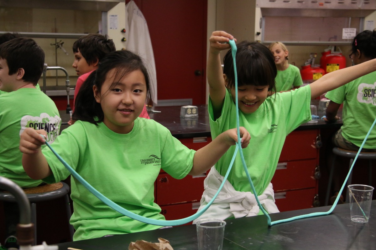 Kids in matching shirts doing a hands-on science experiment